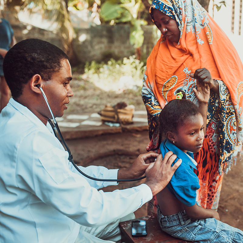 Doctor examining child in tribal setting